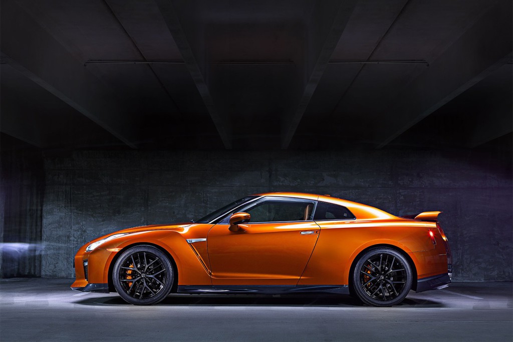 The 2017 GT-R's exterior receives a thorough makeover. The new V-motion grille, one of Nissan's latest design signatures, has been slightly enlarged to provide better engine cooling and now features a matte chrome finish and an updated mesh pattern. A new hood, featuring pronounced character lines flowing flawlessly from the grille, has been reinforced to enhance stability during high-speed driving. A freshly designed front spoiler lip and front bumpers with finishers situated immediately below the headlamps give the new GT-R the look of a pure-bred racecar, while generating high levels of front downforce.